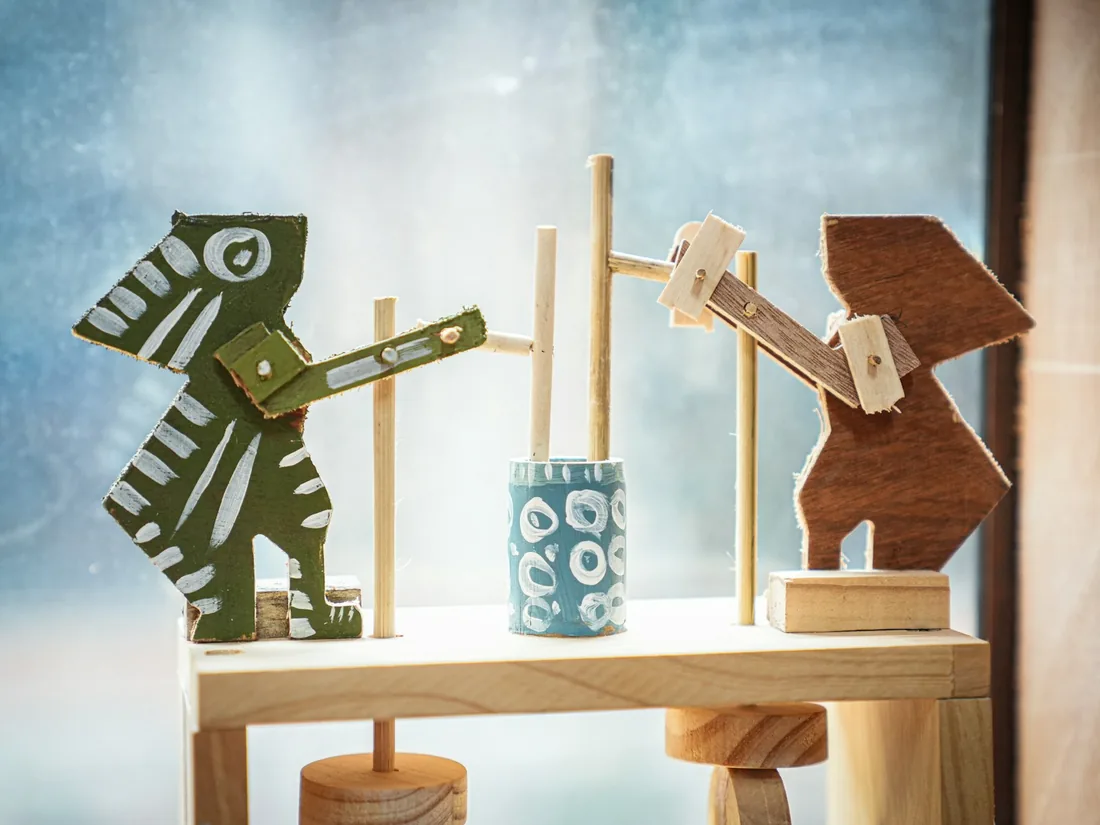 Figuras y piezas de juguetes de madera sin pintar sobre un tablero de trabajo